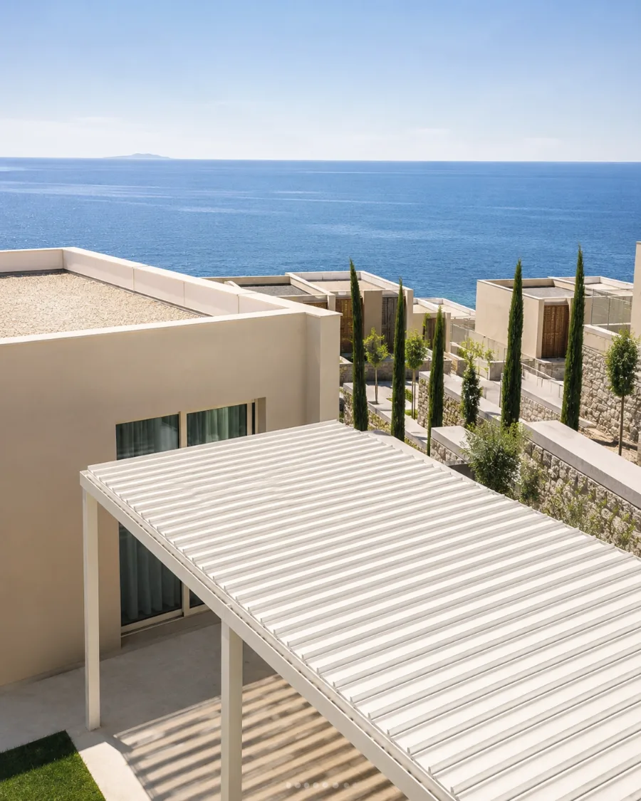 Weisses Lamellendach über der Terrasse einer Ferienresidenz mit Blick auf das Meer